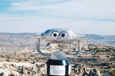 Close-up of coin-operated binoculars against sea