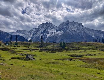 Scenic view of field and mountains against sky