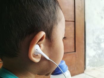 Close-up portrait of boy holding camera