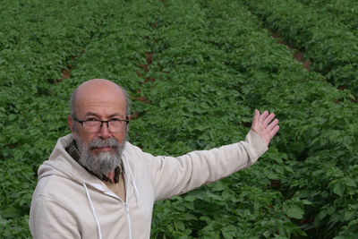 Portrait of senior man standing in field 