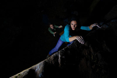 High angel view of women climbing on rock at night