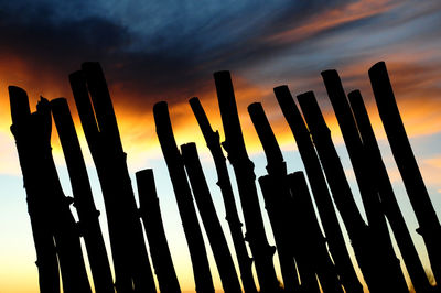 Silhouette fence against orange sky