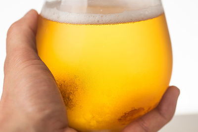 Close-up of hand holding beer glass