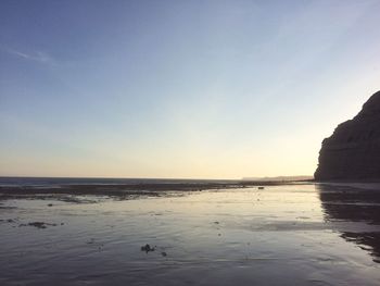 Scenic view of sea against clear sky at sunset