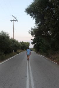 Rear view of man riding motorcycle on road