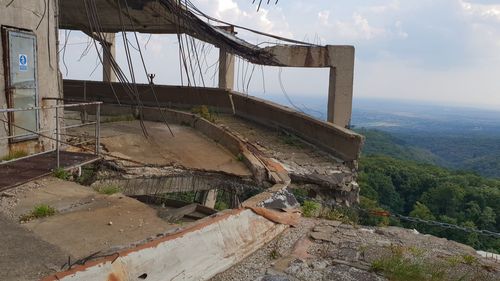 Abandoned car on land against sky