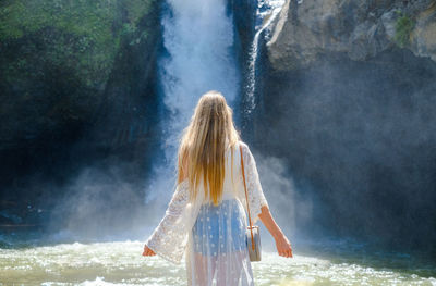 Girl on the background of a waterfall. tegenungan, bali, indonesia.