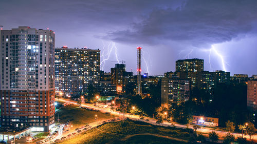 Illuminated buildings in city against sky at night