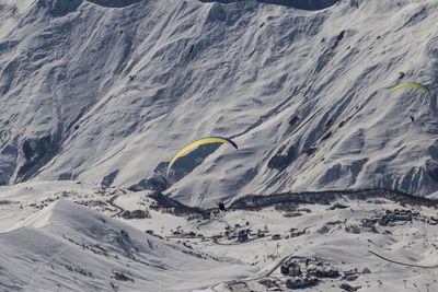 Scenic view of people paragliding