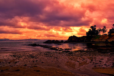 Scenic view of beach against dramatic sky