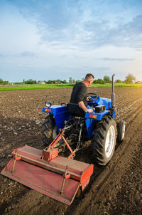 A farmer is cultivating a field before replanting seedlings. milling soil. softening the soil