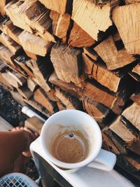 High angle view of woman holding coffee cup on table