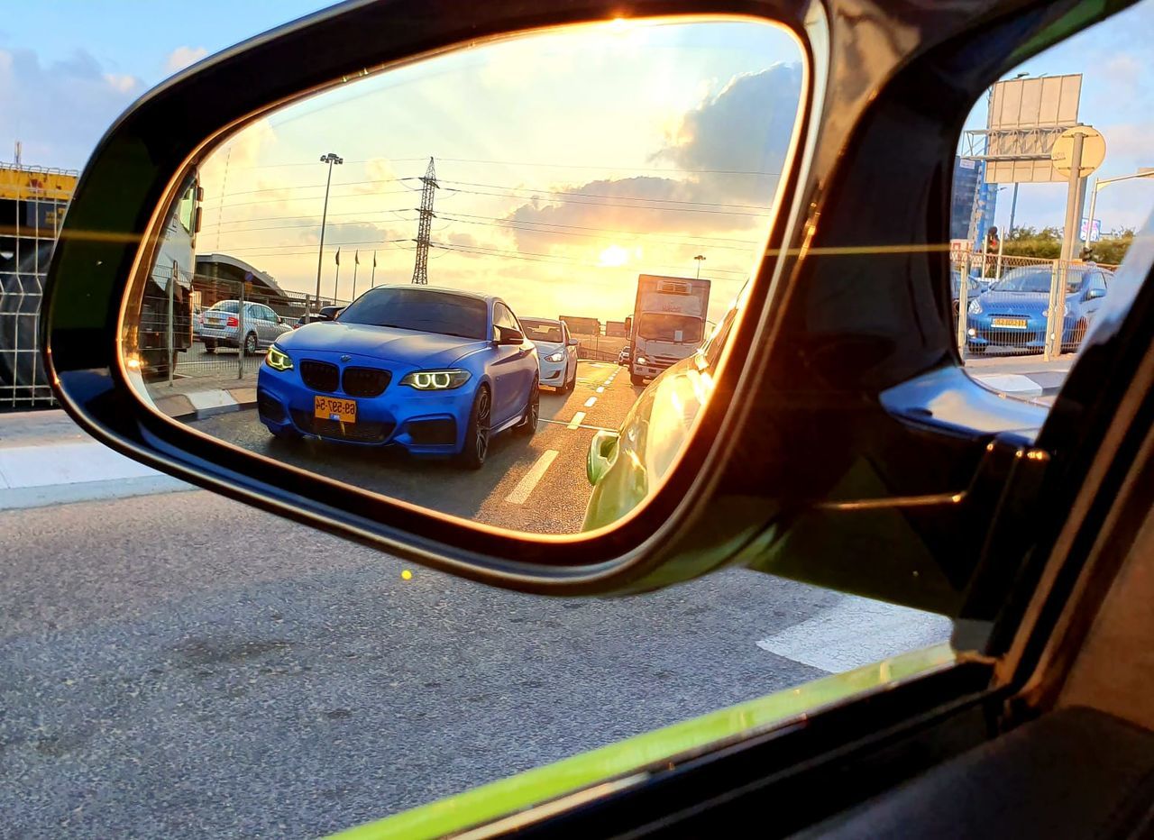 mode of transportation, transportation, car, motor vehicle, land vehicle, reflection, side-view mirror, road, city, sky, architecture, no people, street, nature, travel, mirror, glass - material, vehicle interior, cloud - sky, day, outdoors, vehicle mirror, road trip