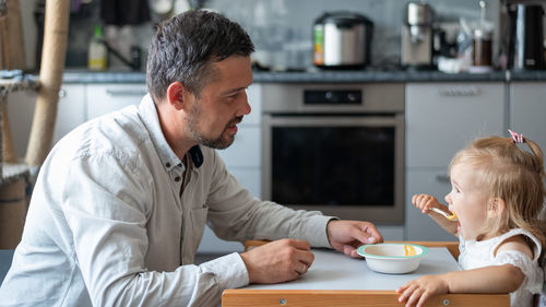 Side view of mother and son on table