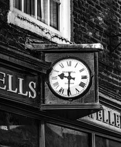 Low angle view of clock on building wall