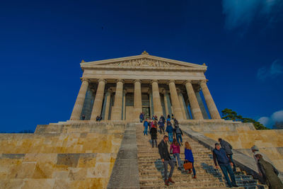 Group of people at traditional building against blue sky