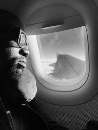 Reflection of man on glass of airplane