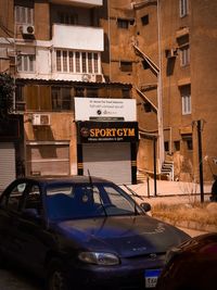 Information sign on road by buildings in city