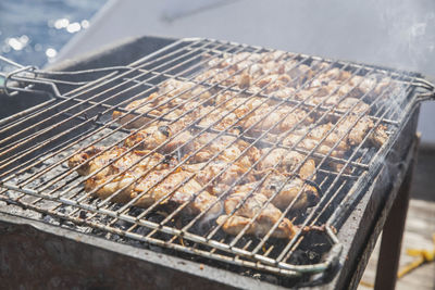 Appetizing meat is frying on the grill on a yacht 