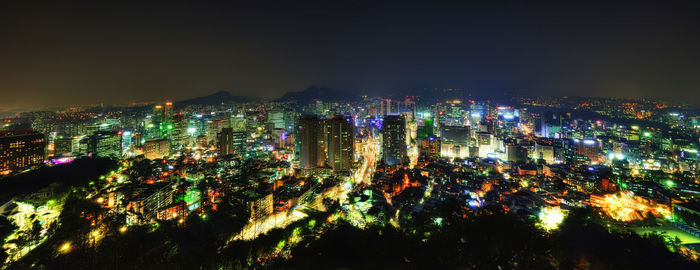 High angle view of illuminated buildings against sky at night