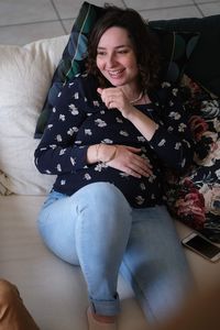 High angle view of woman sitting on sofa at home