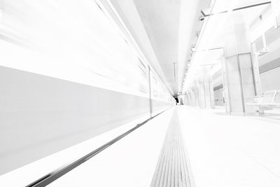 Man on escalator in illuminated underground walkway