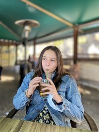 Teenager sitting drinking soda