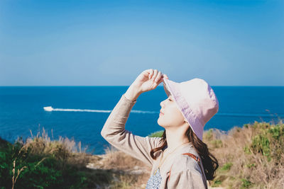 Full length of senior woman on beach against sky