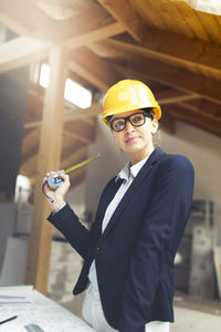 Architect wearing hardhat while working at construction site