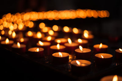 Close-up of illuminated tea lights in darkroom