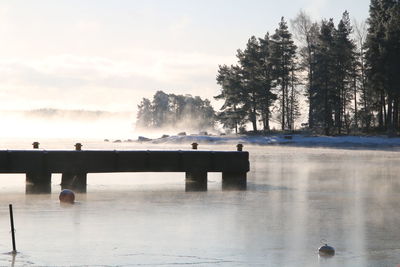 Scenic view of lake against sky during winter