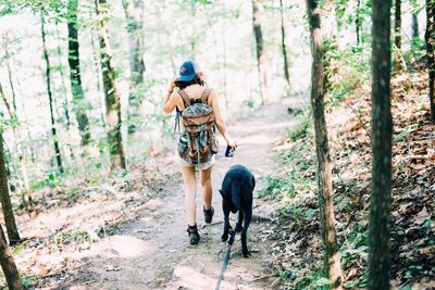 Full length of friends walking in forest