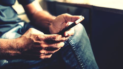 Midsection of man using phone