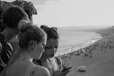 People looking at phone by the beach in france