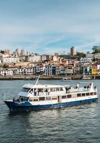 Boats in sea by buildings in city against sky