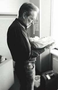 Side view of senior man standing at home