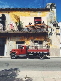 Workers in balcony lifting wooden grate transported from truck