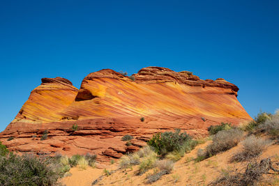 Rock formations on mountain against clear blue sky