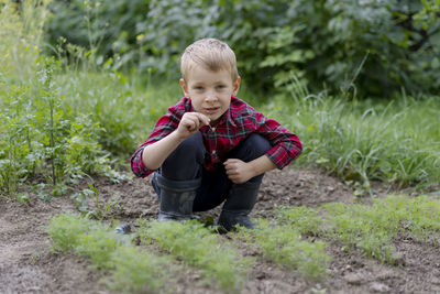 Portrait of boy sitting on field