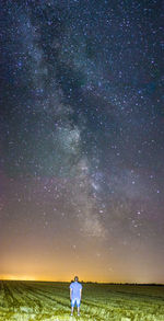 Full length of woman standing on field against sky at night