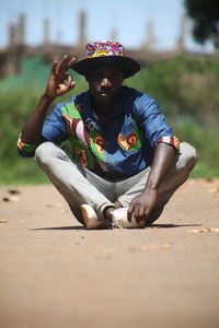 Full length of young man sitting outdoors