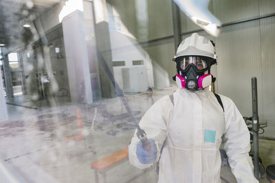 Firefighter disinfecting walls and floors inside a building