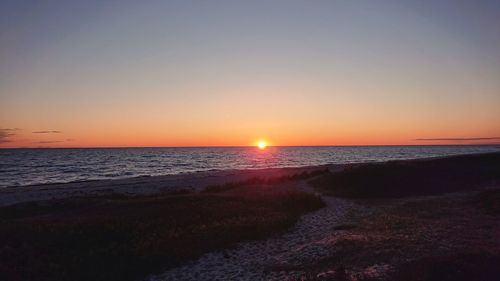 Scenic view of sea against clear sky during sunset