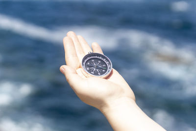 Close-up of hand holding navigational compass