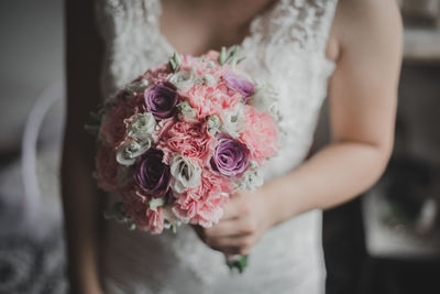 Midsection of woman holding rose bouquet