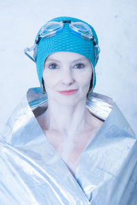 Portrait of smiling swimmer wrapped in silver textile