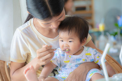 Midsection of woman holding baby while sitting outdoors