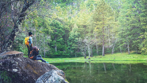 Rear view of woman standing by lake