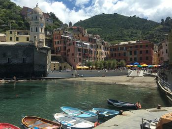 Boats moored in sea against buildings in city