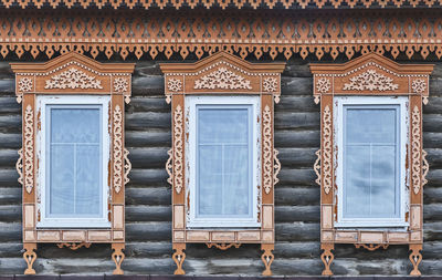 Three traditional windows with carved wood platbands, merchant house of 19th century,yelabuga,russia